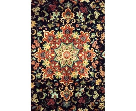 A YAZD CARPET, PERSIANThe dark indigo field with a bold madder medallion with pale indigo spandrels, all with floral sprays, 