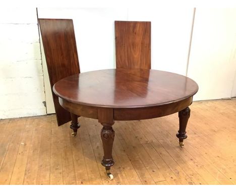 A 19th century mahogany extending dining table, the oval top enclosing two additional leaves, raised on moulded baluster legs