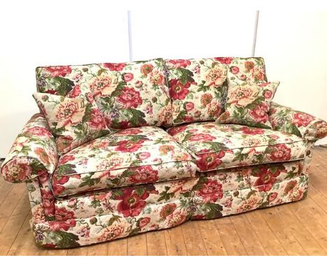 A modern floral upholstered three-seater sofa, with detachable cushion back and seat, between outswept arms, raised on castor