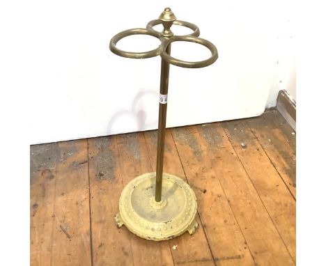 An Edwardian brass stick stand, with urn finial and three hoop divisions, on a turned column and painted iron base. 66cm by 2