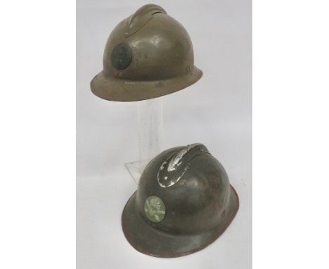 Two French M1926 Steel Helmets khaki green painted, one piece crown and brim. Top attached comb. One with Infantry front badg