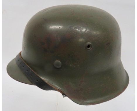 German M1942 Raw Edge Steel Helmet green painted, raw edge steel helmet. Tan leather, 8 tongue liner on a zinc securing band 