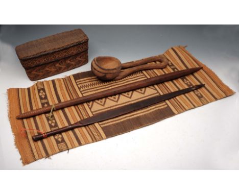 AN ABORIGINAL HARDWOOD SPEAR THROWER, 76.5cm long; another similar item; a carved and incised wooden ladle; a basket work box