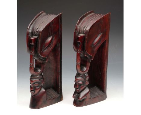 A PAIR OF AFRICAN CARVED WOODEN BOOK ENDS with figure and elephant tusk motif, 27cm