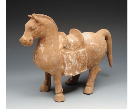 AN ANTIQUE CHINESE TANG STYLE POTTERY MODEL of a horse with saddle, old repairs and traces of white decoration, 31cm long x 2