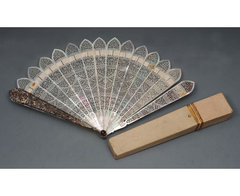 A 19TH CENTURY MOTHER OF PEARL FAN, the sticks intricately pierced with stylised flowers and scroll work, the pierced cut ste