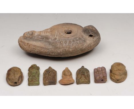 A ROMAN CRUZIE OIL LAMP with mask decoration, 10cm; together with a group of seven Egyptian pottery charms of scarab and mask