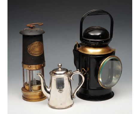 A BRASS AND IRON MINER'S LAMP by Thomas & Williams Ltd, Aberdare, 25cm high; a black painted and brass railway lamp; and a si