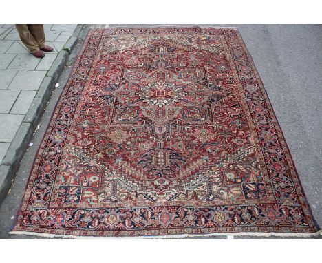 A HEREZ RED GROUND SMALL CARPET with a central stylised rosette motif and within a field of scrolling flowers and geometric d