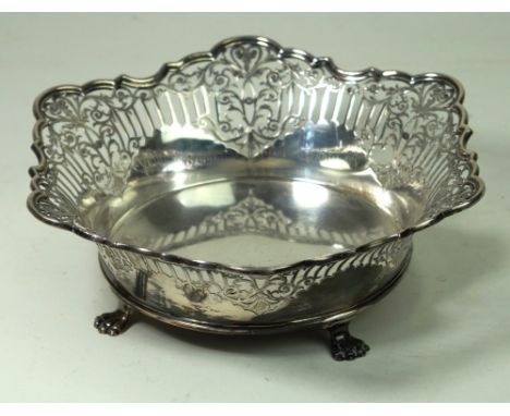 A silver pierced bowl
Of circular form, with vertical and scroll pierced decoration above a scalloped lower body, a wavy rim,