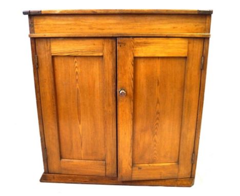 A pitch pine side cupboard, early 20th Century
The flat rectangular top fitted with two rising doors enclosing shallow storag