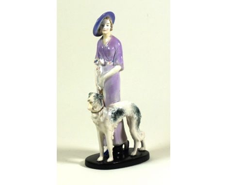 Art Deco Goebel ceramic figurine 
Depicting a girl wearing a purple dress beside a greyhound, raised on a black painted plint