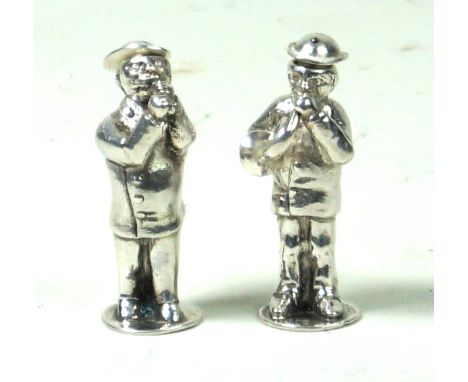 A Victorian silver pair of novelty pepperettes
Each depicting a gentleman playing a musical instrument, one playing a whistle