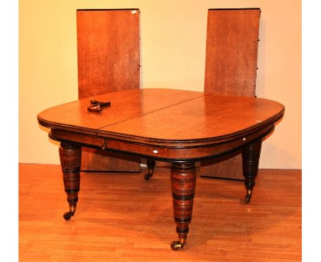 A Victorian oak telescope dining table, with two additional leaves, raised on ring turned supports, 80cm high x 229cm long x 