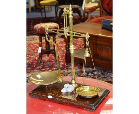 A set of vintage brass pharmaceutical scales, raised on wooden base, 49cm high