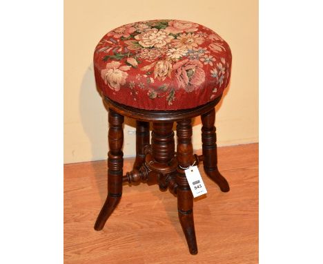 A late Victorian revolving piano stool, with later fabric floral covered top, raised on ring column and turned supports, 50cm