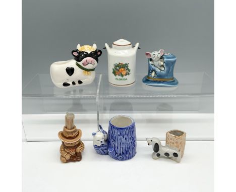 Fantastic collection of containers that includes a dog next to a basket, a cat sitting next to a log, a grumpy cow, a milk ju