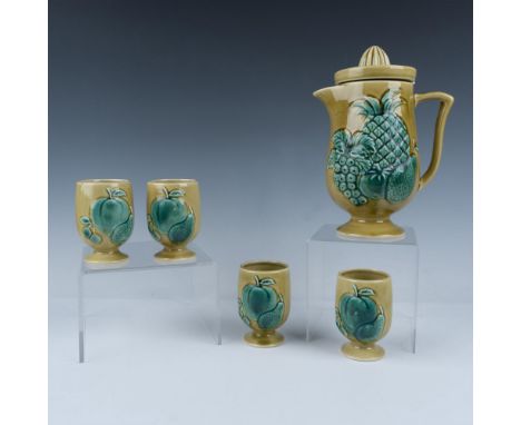 Hand painted porcelain with green fruit motif in high relief on a yellow glossy finish. Features a pitcher with juicer reamer