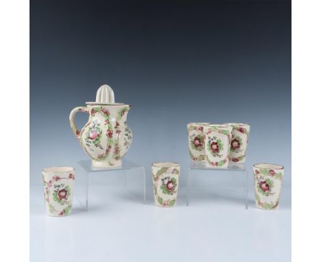 This charming set includes a pitcher with a juicer and six accompanying cups, all decorated with an embossed, hand-painted fl