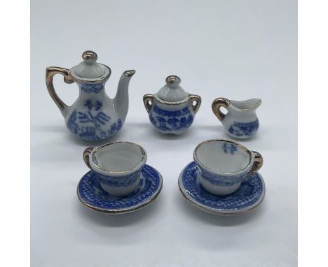 An adorable miniature toy tea set with gold gilded details and Japanese imagery including fishermen, birds and houses. This s
