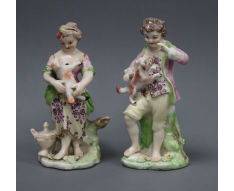 A pair of Derby groups of a boy and a girl, c.1770, the boy holding a puppy and the girl a lamb, patch marks, 13 and 12cmProv
