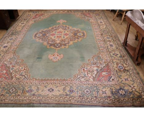 A Turkish green medallion carpet (worn in places and with one burn mark) 416cm x 300cm