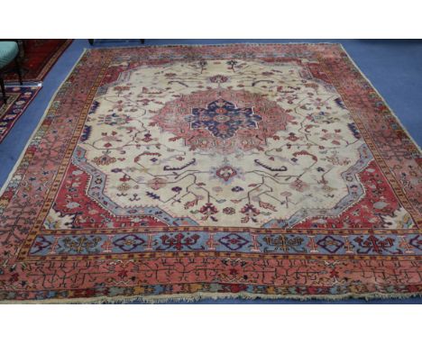 A Turkey pink and cream medallion carpet (worn in places and frayed at one end) 410 x 313cm