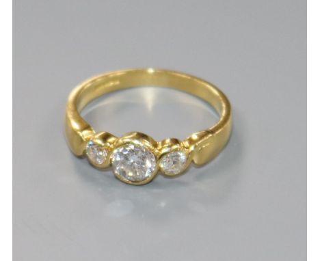 A modern 18ct gold and three stone collet set diamond ring, size N.