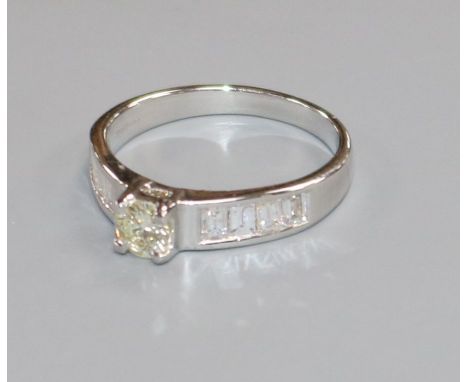 A modern 18ct white gold and single stone diamond ring, with baguette cut diamond set shoulders, size M.