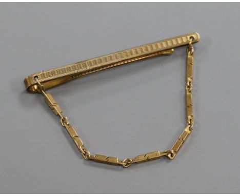 A 9ct. gold tie clip with chain.