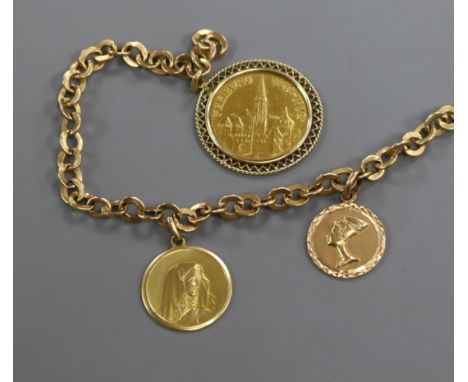 A yellow metal bracelet hung with two 18ct gold charms and a mounted gold medallion.