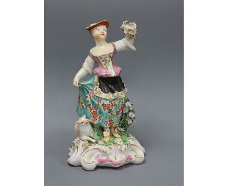 A Derby figure a shepherdess, c.1765-70, standing and holding a garland of flowers, a sheep by her feet, on a scrollwork base