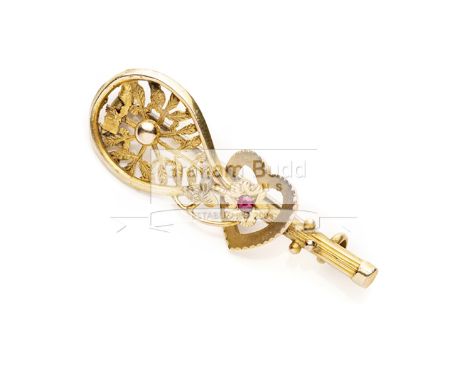 9ct. gold lop-sided tennis racquet brooch with ball on the strings and heart shaped ruby resting on the handle,hallmarked for