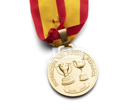 A gold medal awarded to Zindine Zidane for winning the 2001 Supercopa de Espana, with Real Madrid,of circular form with Super