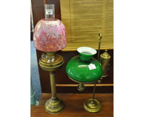 Early 20th century double oil burner having a clear glass chimney, ruby coloured glass shade, standing on a brass base. Toget
