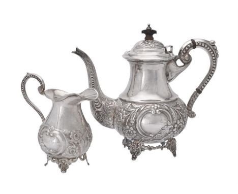 
	
		An Indian silver coloured baluster tea pot and cream jug, stamped Silver, the teapot with a wood finial to the foliate c