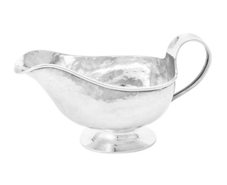 
	
		A silver oval sauce boat by A. E. Jones, Birmingham 1919, the hammered body with a loop handle and on an oval pedestal f