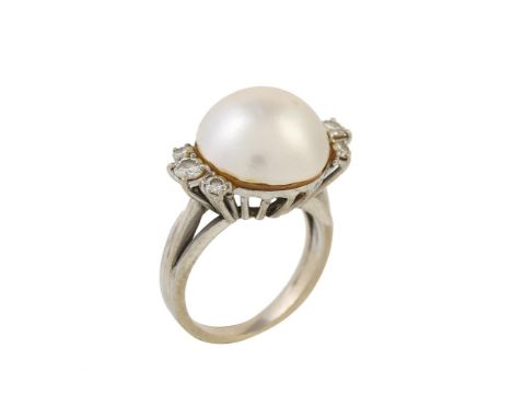 
	
		A mabé pearl and diamond ring, the mabé pearl measuring 13mm diameter, flanked by two trios of brilliant cut diamonds, a