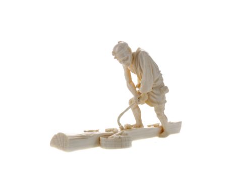 JAPANESE IVORY CARVING OF A MAN, Meiji period, the figure removing bark from a log using a hand tool, his right foot raised o