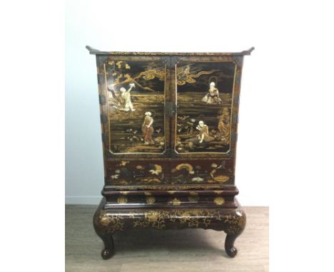 JAPANESE LACQUERED AND SHIBAYAMA CABINET ON STAND, painted allover with gilt scrolling foliate decoration, the two hinged doo