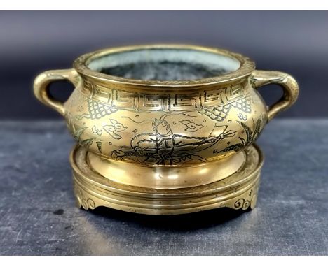 A Chinese polished bronze twin handled censer,&nbsp;Xuande six character seal mark to base, 22cm wide, on similar stand. 