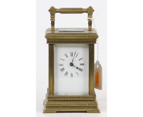 An early 20th century French lacquered brass carriage clock, having white enamelled dial, visible platform escapement, single