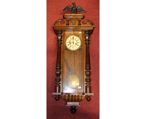 An early 20th century Vienna walnut cased drop trunk wall clock having eagle pediment, height 120cm