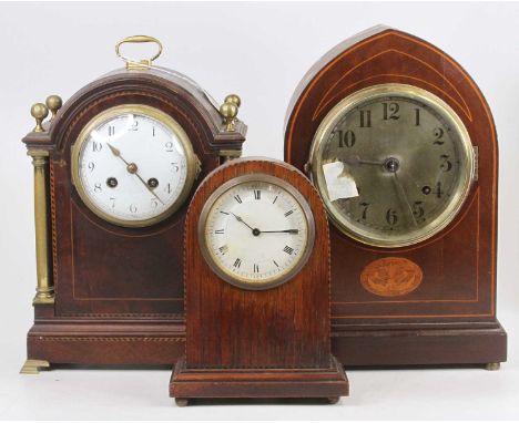 An Edwardian inlaid mahogany dome topped mantel clock, having brass columns, convex white enamel dial, spring-driven eight-da