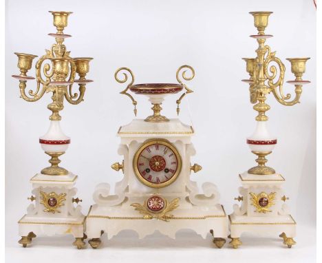 A late 19th century alabaster and gilt metal three-piece clock garniture, the garniture each having four candle lights (one d