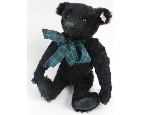 A Steiff plush jointed Black Watch Teddy bear, in black with musical action, wearing a tartan type blue and green bow, with p