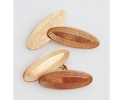 A pair of 9ct gold cufflinks, each with oval part engine turned ends and chain centres, 3cm wide, 6g.  (2)