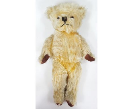 A mid 20thC blonde plush jointed Teddy bear, of small proportion with shaped velvet pads and glass eyes, unmarked, 28cm high.