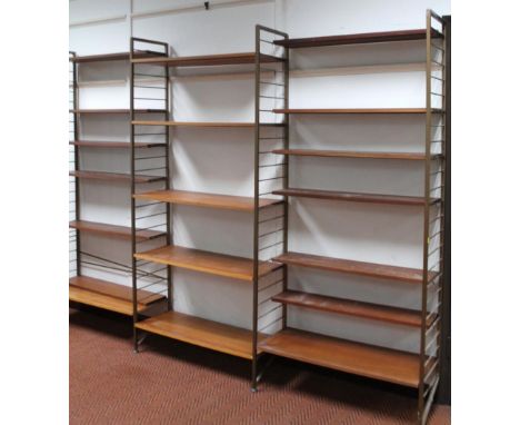 A retro Ladderax metal book shelf, with shaped supports and wooden shelves, 203cm high,284cm wide,38cm deep.