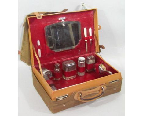 An early 20thC campaign travel case, in pressed brown leather with chrome mounts and outer khaki canvas bag, the hinged lid r